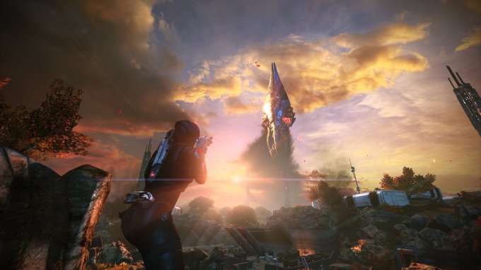 Cena de Mass Effect 1, com a personagem Sheppard de armadura e arma em punho, mirando para uma nave espacial alienígena ao fundo, de frente a uma base