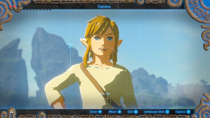 Link (de Zelda) fazendo pose para foto em frente a duas montanhas