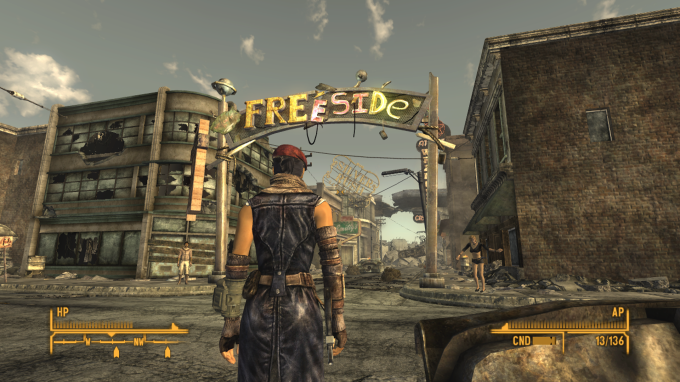 A protagonista em frente a um grande portão feito de sucatas com uma placa escrito &quot;Freeside&quot;