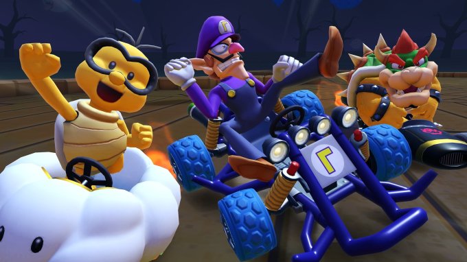 Personagens Lakitu, Waluigi e Bowser em karts, em pista de corrida de temática fantasma