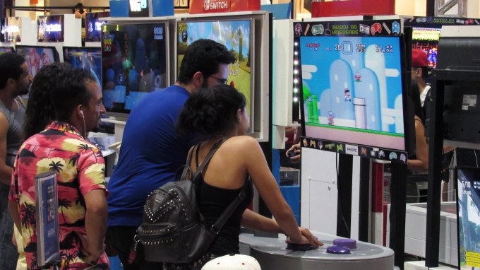 Pessoas jogando Super Mario World em controle gigante