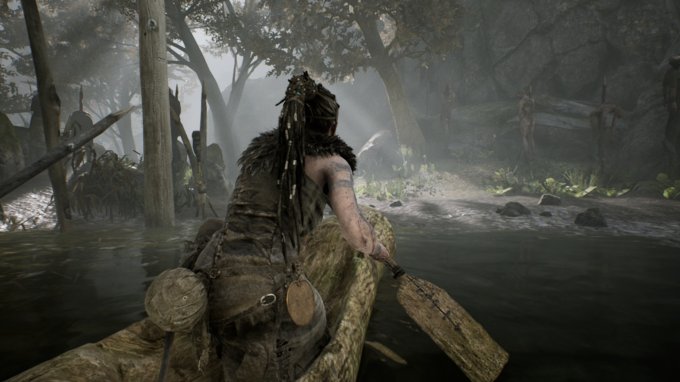 Senua em uma canoa perto da margem de uma floresta, com algumas pessoas empaladas ao fundo