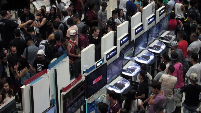 Pessoas jogando em estações de consoles diversos